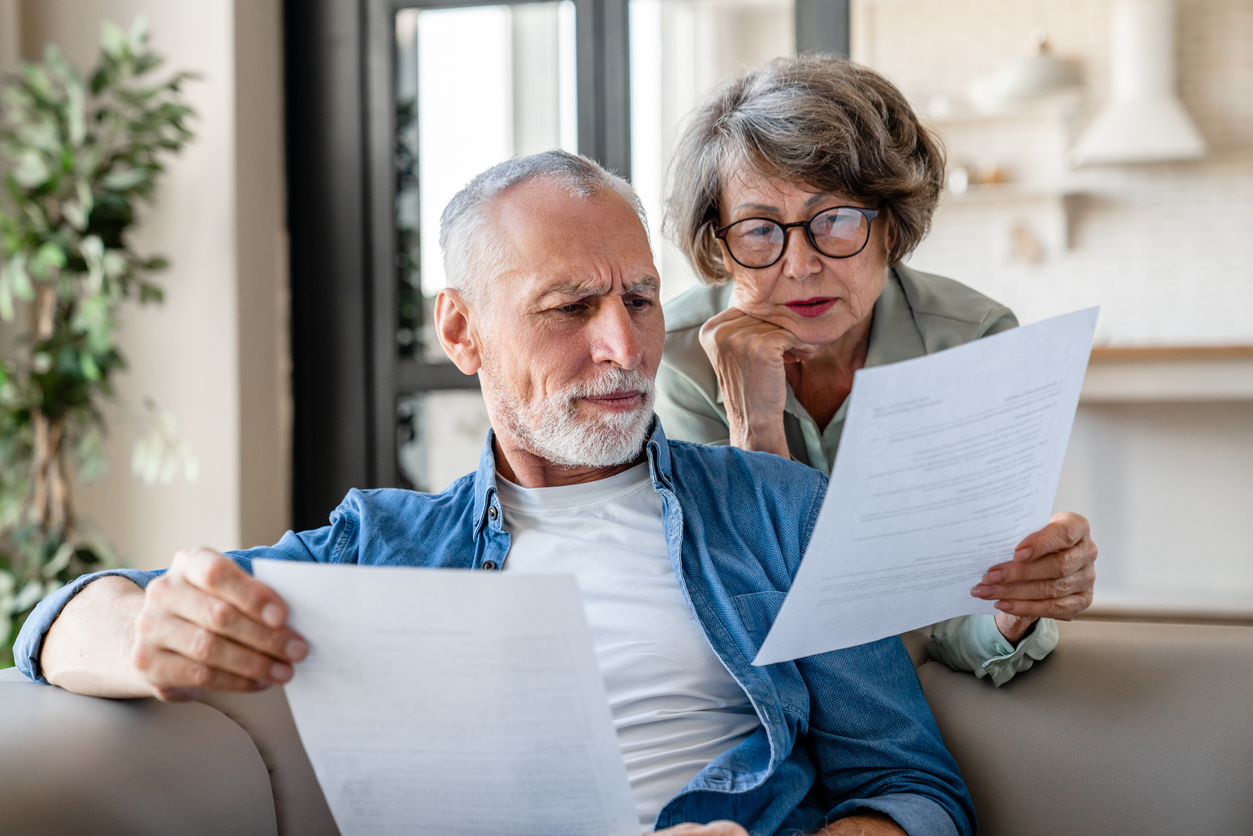 Senior grandparents reading documents, having issue problem debt with money loss retirement questions