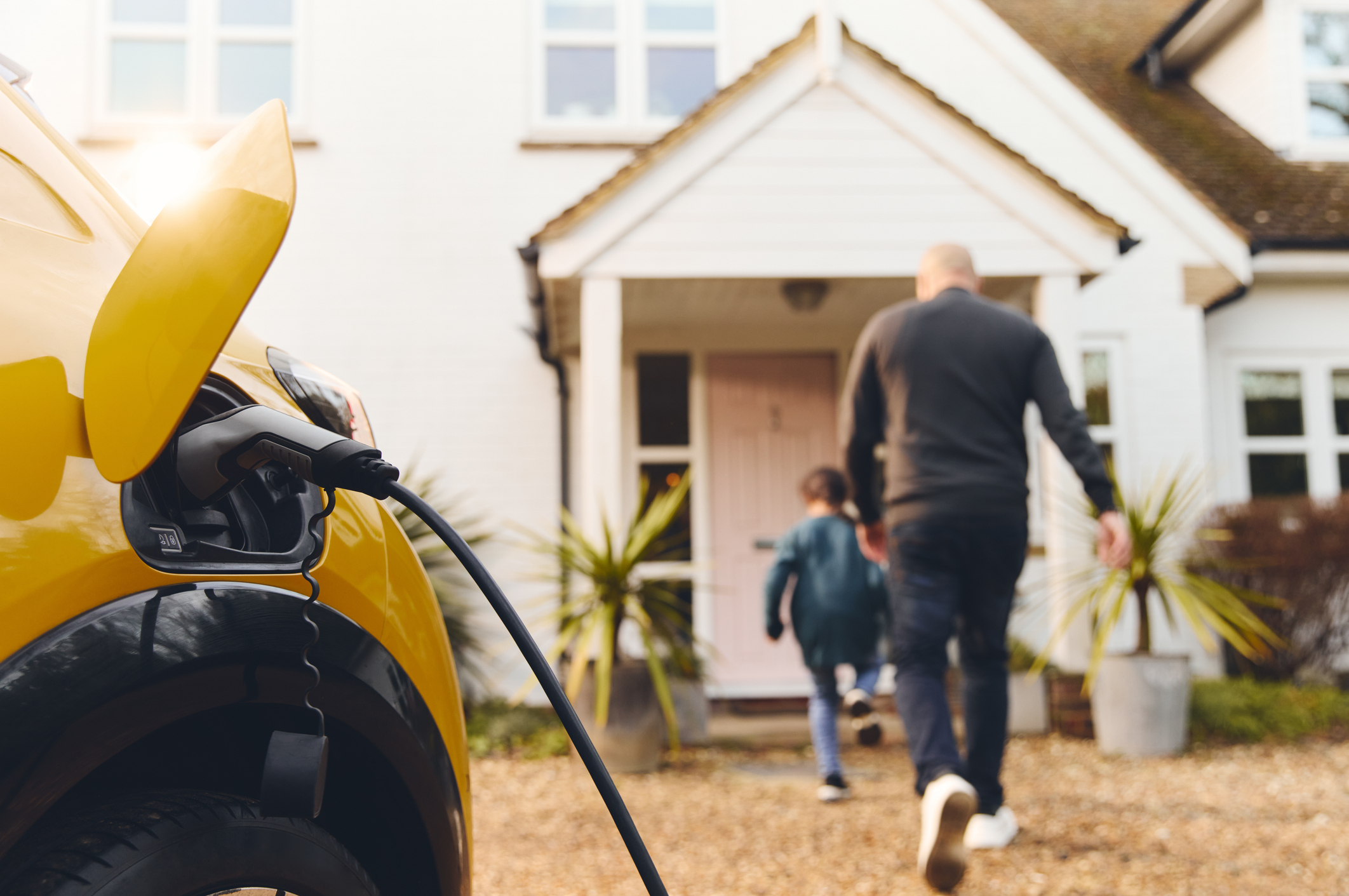 Electric car charging on driveway outside house clean air credit